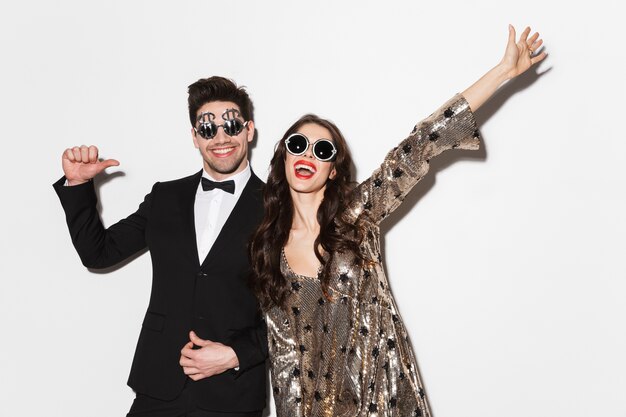 Retrato de una bonita pareja alegre celebrando las vacaciones juntos aislado sobre blanco