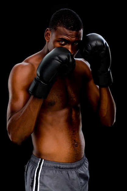 Retrato de un boxeador muscular sin camisa en posición defensiva