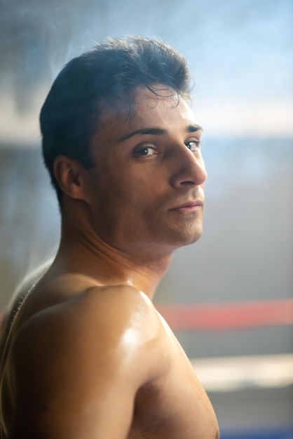 Foto retrato de boxeador serio sin camisa en el ring. guapo portugués con cuerpo musculoso en el campeonato. concepto de atleta