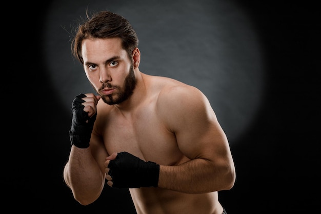 Retrato de un boxeador con vendas en las manos Puños de un luchador antes de una pelea o entrenamiento en el gimnasio El concepto de deporte