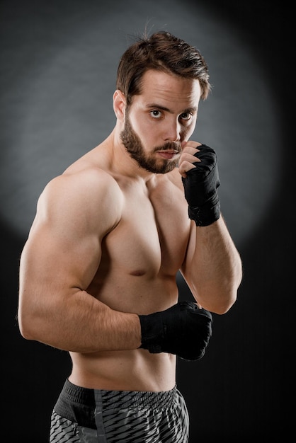 Foto retrato de un boxeador con vendas en las manos puños de un luchador antes de una pelea o entrenamiento en el gimnasio el concepto de deporte