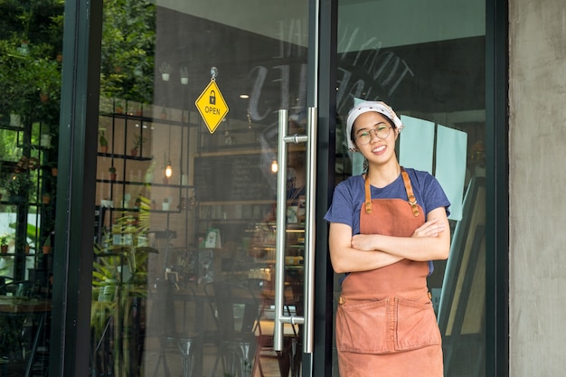 El retrato de los brazos derechos de la camarera bastante joven cruzó en café.