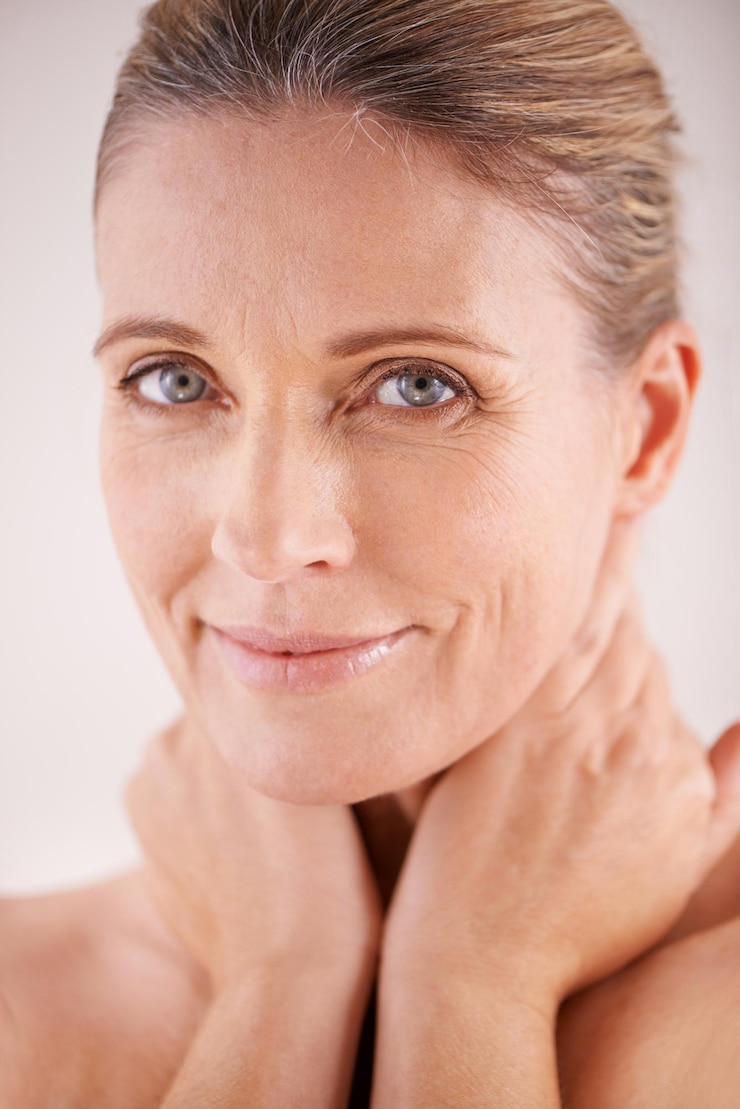 Foto retrato brilhante ou mulher madura com confiança de beleza ou tratamento facial em estúdio em fundo branco benefícios de cuidados com a pele do rosto ou modelo com brilho natural sorriso ou resultados de cosméticos anti-envelhecimento