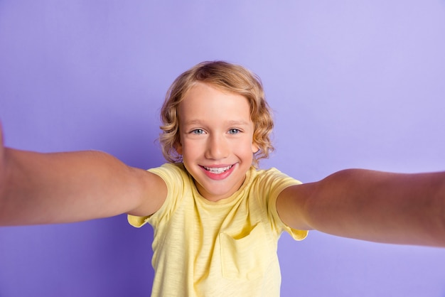 Retrato de buen humor chico chico hacer selfie sonrisa con dientes usar ropa de estilo casual aislado sobre fondo de color púrpura