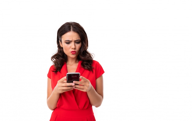 Retrato de buena chica caucásica serfing internet con su teléfono inteligente en blanco