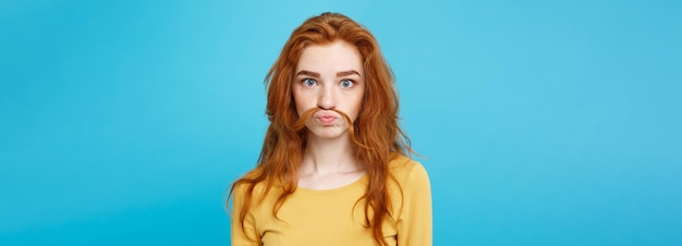 Retrato en la cabeza de una chica feliz de cabello rojo jengibre imitando a un hombre con cabello falso bigote pastel b