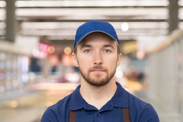 Retrato de cabeza y hombros de apuesto joven que trabaja en el supermercado