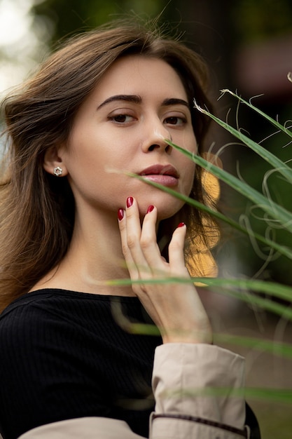 Retrato de la calle de moda de una mujer bonita morena con maquillaje natural viste elegante abrigo beige, caminando por la ciudad de otoño