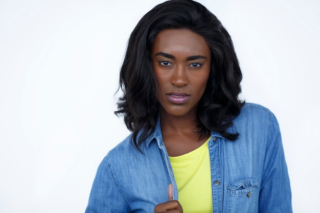 Retrato de la calle de mujer negra sobre fondo blanco en chaqueta de jeans y camiseta amarilla