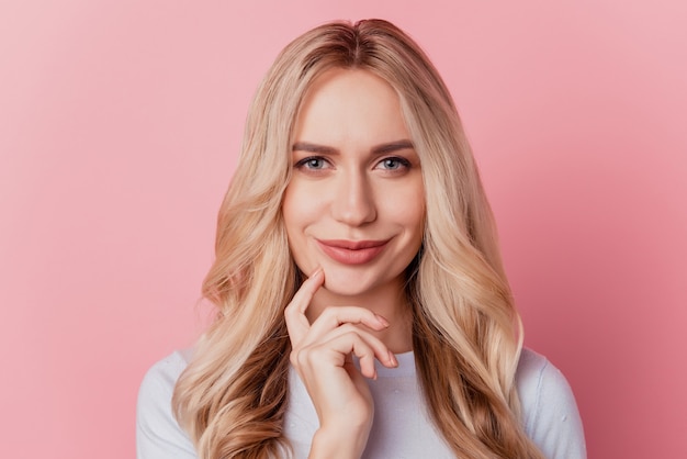 Retrato de cámara de mirada inteligente alegre chica encantadora dedo mejilla sobre fondo rosa