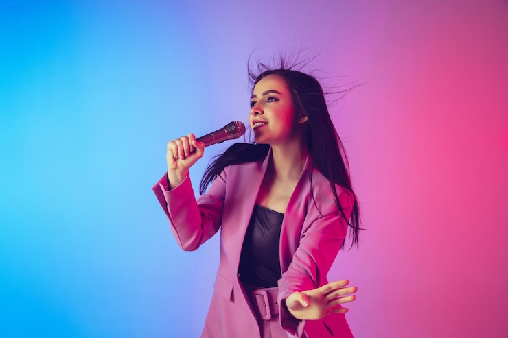 Foto retrato de cantante femenina caucásica aislado sobre fondo de estudio degradado en luz de neón