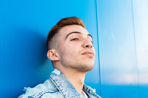 Retrato de la cara de un hombre joven y guapo aislado que parece serio en azul