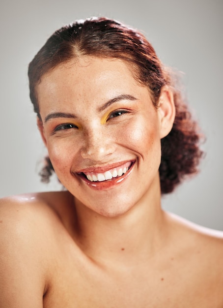 Retrato de cara de maquillaje de belleza y mujer feliz con cosméticos de lujo sombra de ojos brillo de cuidado de la piel saludable o autocuidado Salón de spa de cosmetología facial y sonrisa de modelo estético aislado en el fondo del estudio