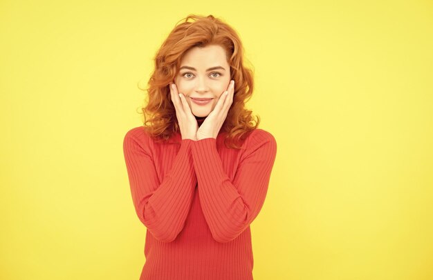 Retrato de cara de mujer pelirroja encantadora sonriendo sobre belleza de fondo amarillo