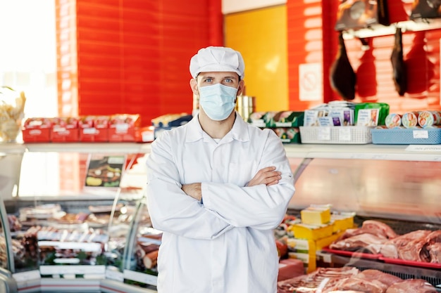 Retrato de un carnicero en una carnicería durante el virus de la corona