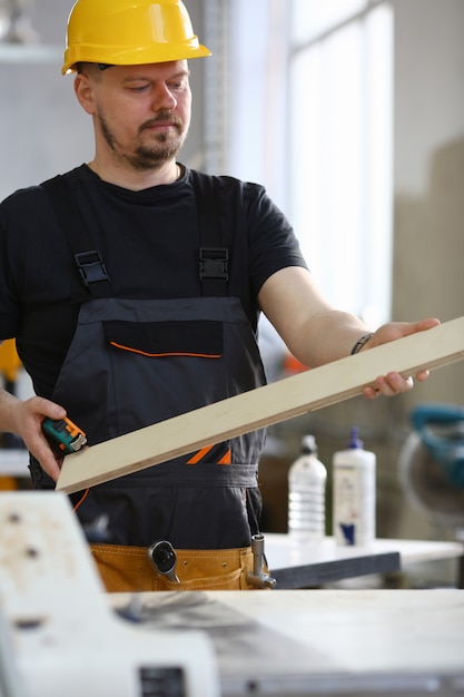 Retrato de un carpintero sonriente con tablones de madera