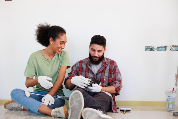 Retrato Casal alegre jovem e mulher negra sorrindo durante a renovação no novo apartamento