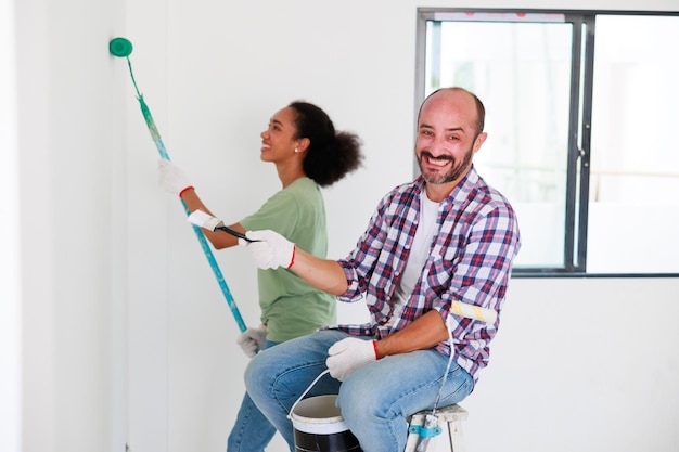 Retrato Casal alegre jovem e mulher negra sorrindo durante a renovação no novo apartamento