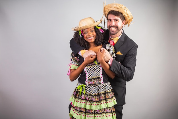 Foto retrato casal brasileiro em roupas de festa junina festa de são joão abraçada