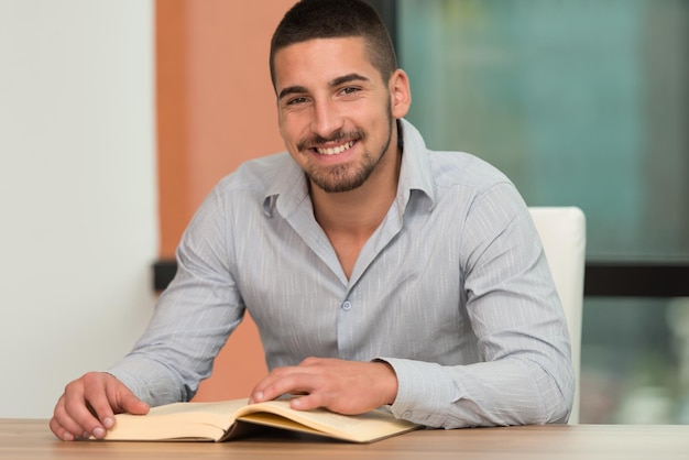 un, retrato, de, un, caucásico, estudiante universitario, hombre, en, biblioteca, poca profundidad de campo