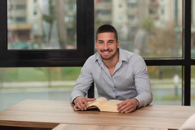 un, retrato, de, un, caucásico, estudiante universitario, hombre, en, biblioteca, poca profundidad de campo