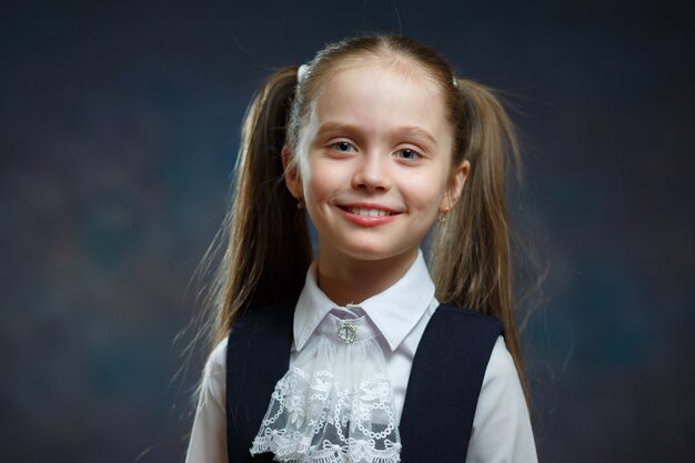 Retrato caucásico sonriente de la colegiala elemental