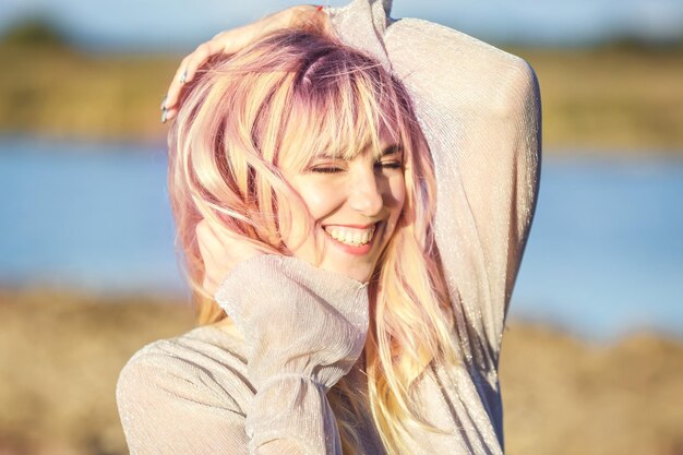 Retrato de cerca al aire libre hermosa chica rubia con juventud y cuidado de la piel atractivo mirando a la cámara Tecla de luz