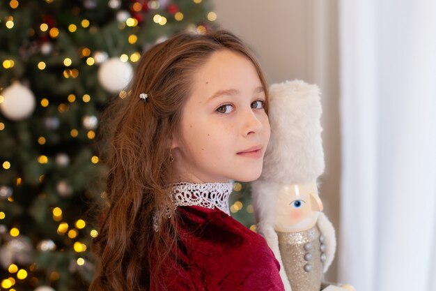 Un retrato de cerca de la cara de una niña sosteniendo un juguete cascanueces