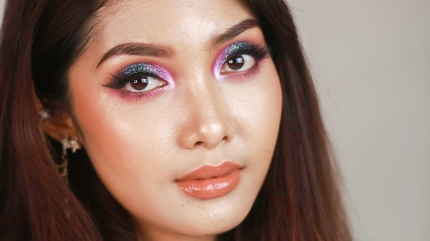 Un retrato de cerca de una hermosa joven con maquillaje colorido