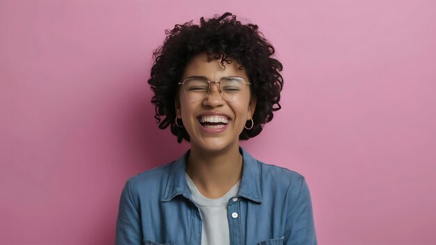 Foto retrato de cerca de una mujer afroamericana feliz que se ríe de algo gracioso tiene expresiones positivas