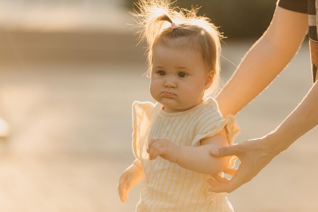 Un retrato cercano de una niña pequeña a manos de una mamá