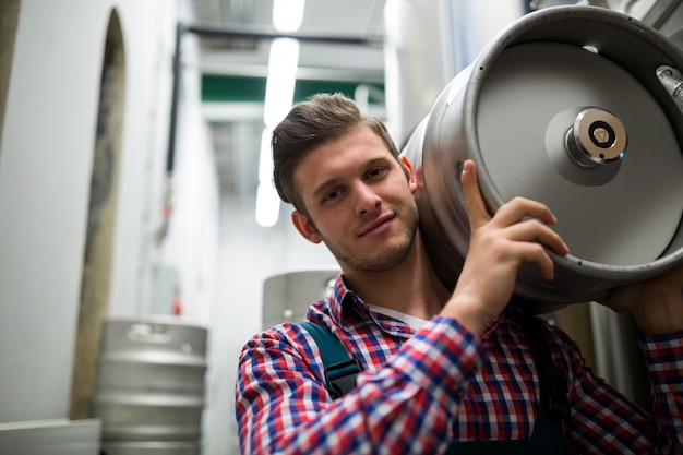 Retrato de cervecero llevando barril