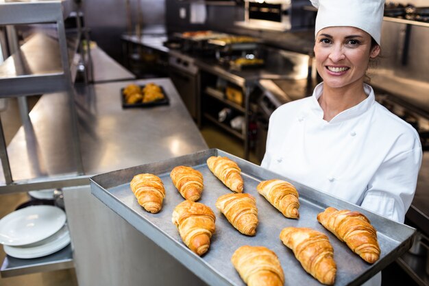 Retrato de un chef con bandeja de croissants