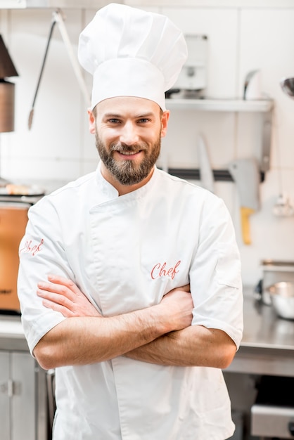 Retrato de chef cocinero en uniforme en la cocina del restaurante