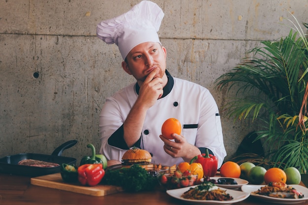 Retrato Chef hombre en cocina con comida y verduras