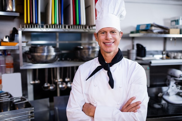 Retrato de chef posando en cocina comercial