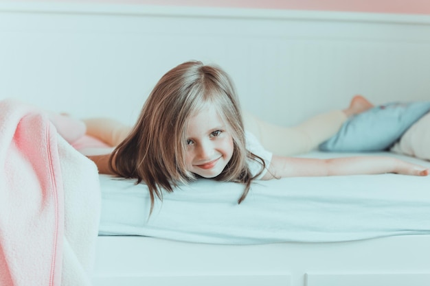 Retrato de una chica acostada en la cama en casa