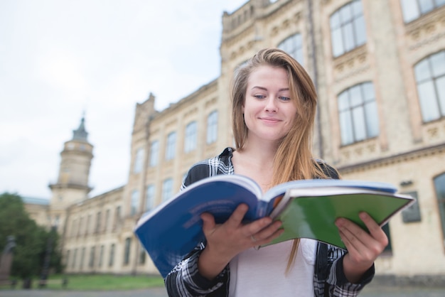 Retrato de una chica estudiante divertida con un cuaderno en sus manos