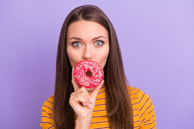 Retrato de una chica funky loca sorprendida conmocionada cerca de ocultar sus labios con un elegante estilo de ropa de donut dulce sabroso colorido jumper aislado sobre color púrpura