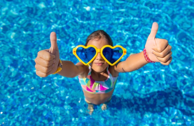 Foto retrato de una chica con gafas de novedad en la piscina