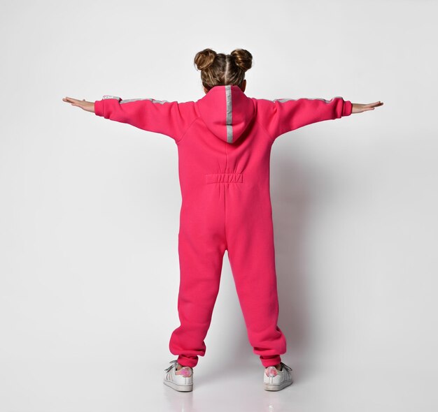 Retrato de una chica genial con un mono rosa con capucha y rayas reflectantes de seguridad de pie con