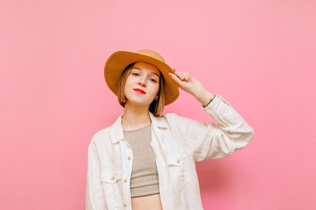 Retrato de una chica guapa con ropa de verano aislada de fondo rosa mirando a la cámara y sonriendo