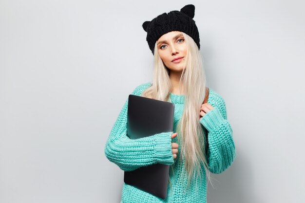 Retrato de una chica guapa rubia con un portátil en las manos