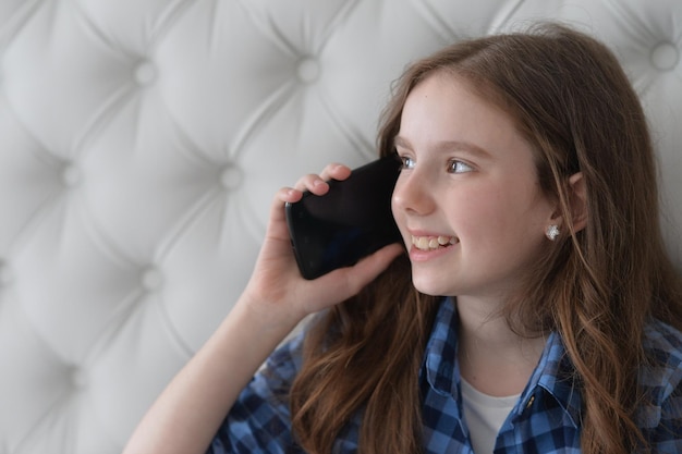 Retrato de una chica hermosa con un smartphone en casa