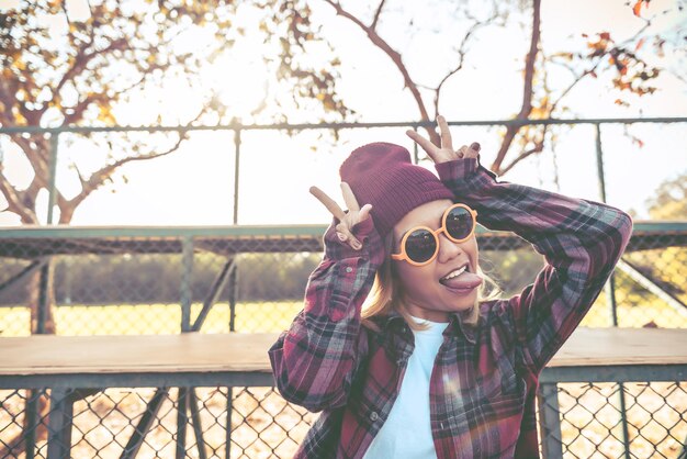 Foto retrato de una chica hipster asiática con estilo vintage de gafas de sol naranjas