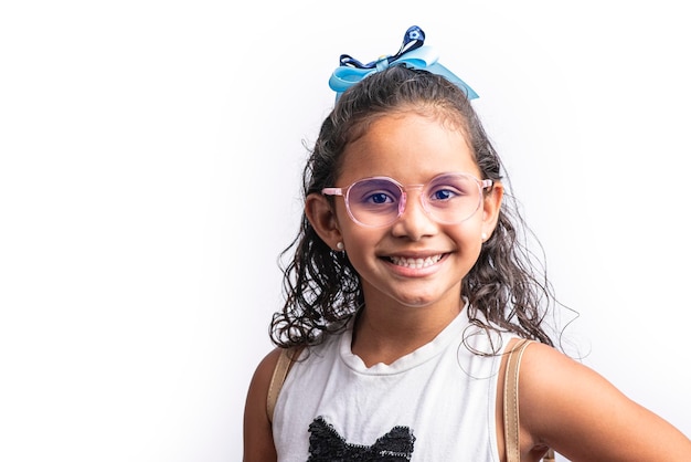 Retrato de una chica latina sonriente con gafas mirando a la cámara sobre un fondo blanco.