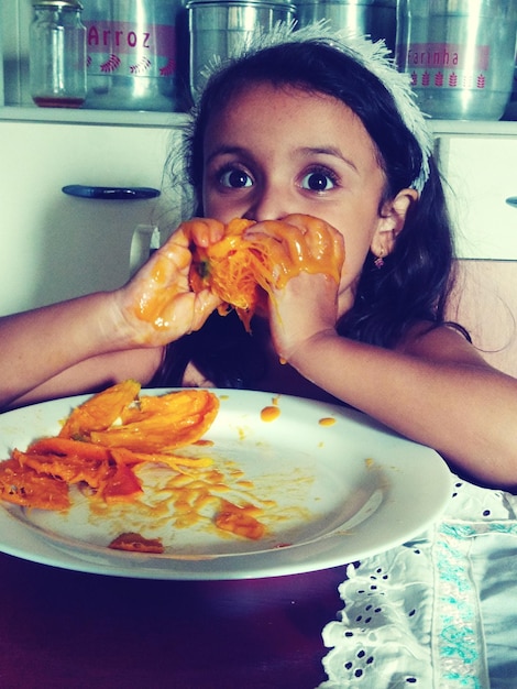 Foto retrato de una chica linda comiendo mango en casa