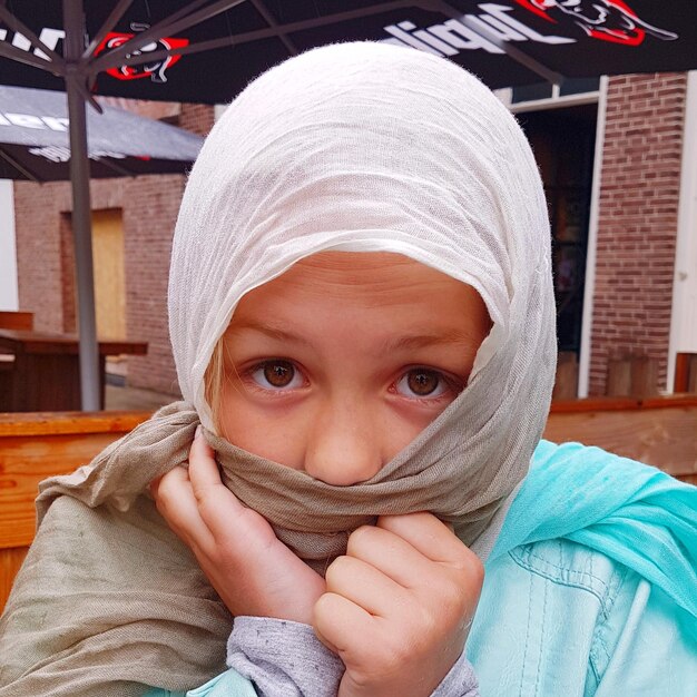 Foto retrato de una chica linda cubriendo la cara con una bufanda
