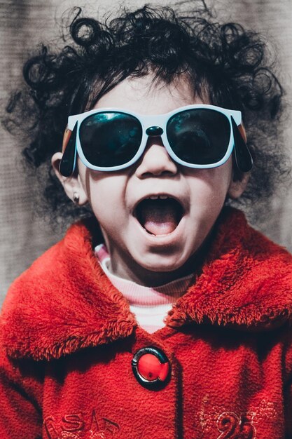 Foto retrato de una chica linda con gafas de sol en casa