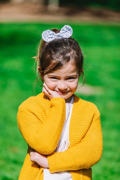 Foto retrato de una chica linda y sonriente de pie en el parque